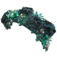 Dunkelgrüner Fascinator mit funkelnden Blüten und Perlen